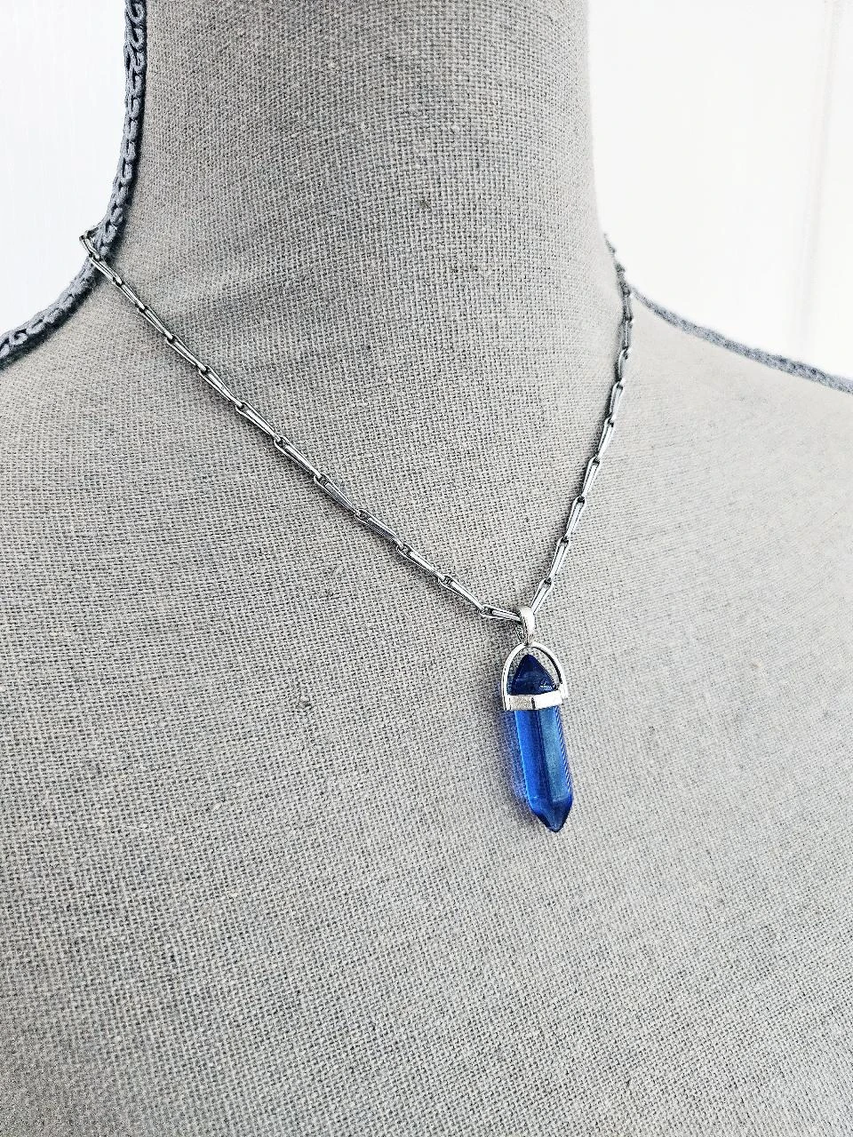 Collier chaine argentée et son pendentif pointe de cristal bleu nuit intense
